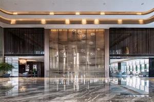 Modern interior design of a hotel lobby featuring glass walls and marble floor.