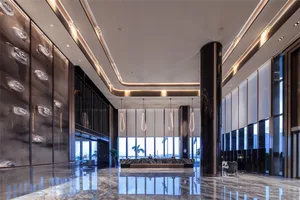 Modern hotel lobby featuring metallic bamboo accents and minimalist design.