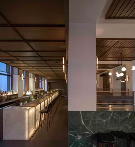 Interior view of a modern industrial restaurant bar featuring marble and concrete materials