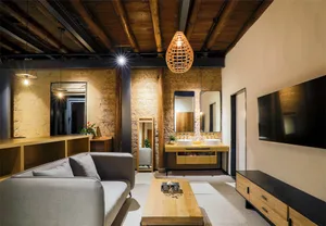 A modern living room with a gray sofa, wooden coffee table, and elegant lighting fixtures.