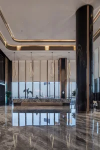 A contemporary marble reception desk in a luxurious hotel lobby.