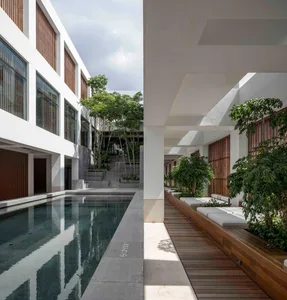 Modern, minimalist residential interior with a concrete poolside area and white walls.