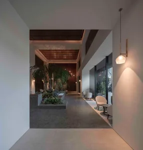 A modern office lobby featuring concrete, glass, and wooden materials.