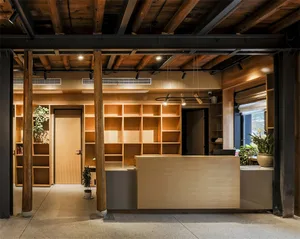 Modern office reception area with wooden furniture and shelving.