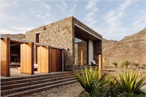 Modern residential building with stone walls and wooden accents.