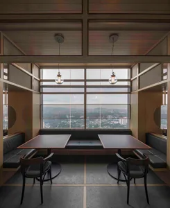 A minimalist restaurant dining room featuring wood and leather materials.