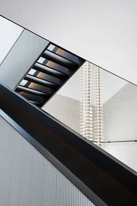 A modern airplane hangar featuring a black metal staircase and glass walls.