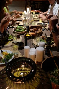 A modern dining room with a wooden table, chairs, and various food items on the table.