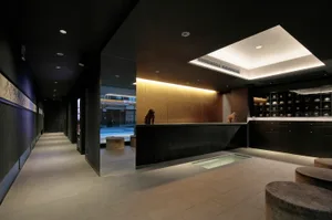 Modern hotel reception area with black interior design and lighting features.
