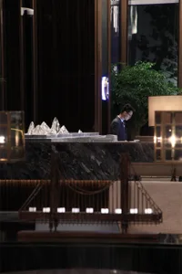 A modern hotel reception desk with marble countertop and glass sculptures.