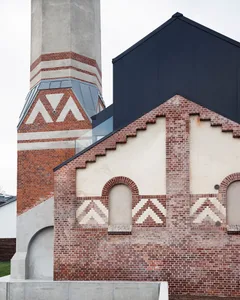 A modern industrial building with brick and concrete materials.