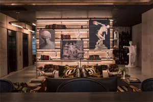 Modern industrial lobby featuring concrete walls, metallic accents, and contemporary art.