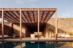 Modern outdoor living space with a wooden roof and pool.