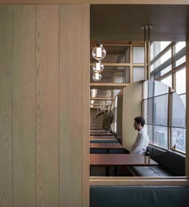 Modern restaurant interior design with wood paneling, glass windows, and metal accents