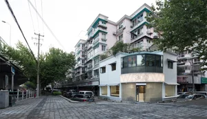 A street view of urban architecture featuring windows, plant balconies, and various building materials.