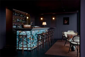 A modern bar area with a tiled bar counter and seating area.