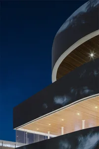 Modern glass architecture building exterior during nighttime with blue sky