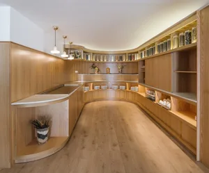 Modern restaurant interior with wooden bar and shelves.