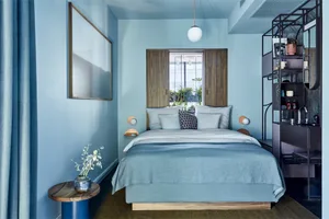 A minimalist bedroom with a blue color scheme.