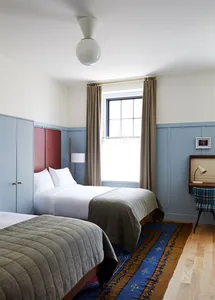 A minimalist bedroom featuring wood, wool, and metal materials and furniture.