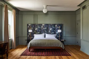 A modern bedroom with a hanging lamp, cozy lighting, and comfortable furnishings.