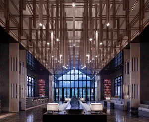 Modern hotel lobby featuring concrete and wood materials with high ceilings and large windows.