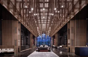 An interior view of a modern hotel lobby featuring marble flooring and a wooden frame