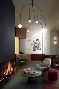 A modern living room featuring metallic lighting fixtures, a fireplace, and contemporary furniture.