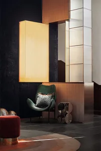 A modern living room featuring textured metallic furnishings, including a green upholstered chair with a metallic pillow.