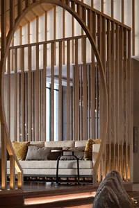 A modern lounge area with a sofa adorned with colorful cushions, situated within a space defined by wooden paneling and arche
