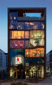A modern residential building featuring glass and concrete exterior materials.