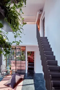 An urban loft interior with a concrete staircase and green roofs.