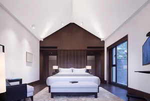 A minimalist bedroom with a large white bed, wooden headboard, and glass panels.