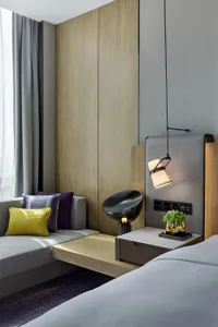 Modern minimalist bedroom featuring minimalist furniture, wooden walls, and a comfortable seating area.