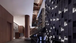 Modern lounge area with concrete walls and lighting embedded in the wall.
