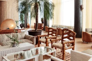 Modern lobby featuring wooden furniture and a rug on a wooden floor.