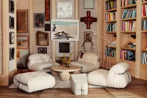 A modern Scandinavian living room with white furniture, wooden flooring, and abstract art on the walls.