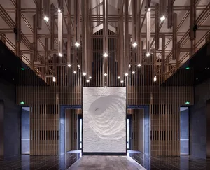 A modern lobby with wooden walls and a central spiral pattern on a white wall.