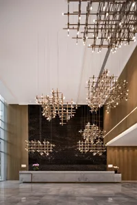 A modern industrial lobby featuring metallic lighting fixtures and a sleek, minimalist design.