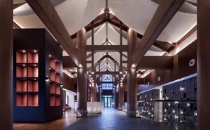Modern lobby interior with wooden columns and high ceilings.