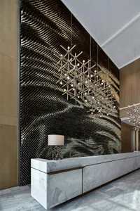 A modern minimalist lobby with a concrete wall and metal accents.