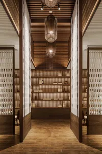 A modern wooden library with shelves filled with books and wooden light fixtures hanging from the ceiling.