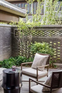 A walled outdoor space featuring wood, brick, and metal elements.