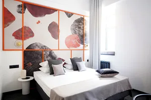 Minimalist bedroom with a sound-absorbing fabric and a decorated wall