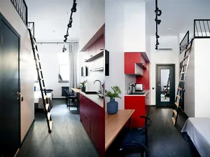 Minimalist residential interior featuring a red kitchen area with an open-plan living space and loft bed.