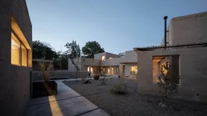 Modern residential exterior with adobe walls and white stucco accents.