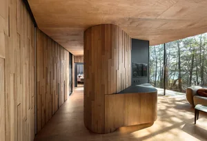 A modern interior space featuring wooden walls and flooring with a central wooden pillar.