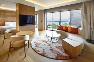 Living room with modern tiles and furniture, featuring a round rug and a sofa.