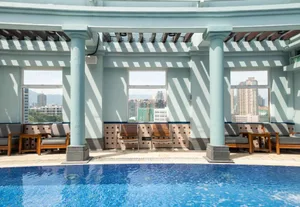 Roof top pool area featuring concrete pillars, tiled walls, and glass windows