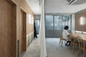 A modern office space featuring industrial materials such as concrete, wood, and metal.